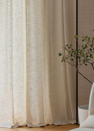 a white couch sitting next to a window covered in curtains