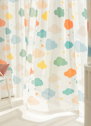 a child's room with a white crib and colorful clouds on the wall