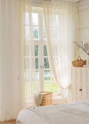 a bedroom with a white bed and white curtains