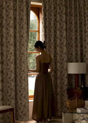 a woman in a dress looking out a window