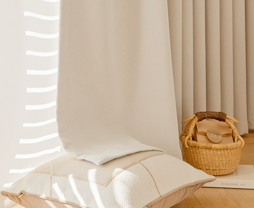 a cozy and inviting living space with a white pillow, a woven basket, and a book on a wooden floor.