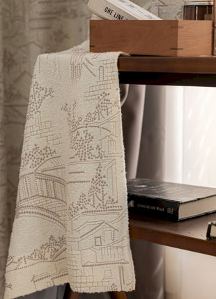 a bookshelf with books and a blanket on top of it