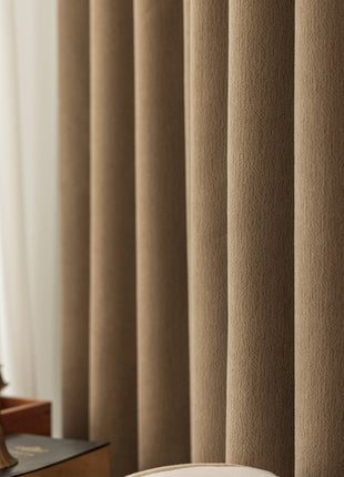 a room with a bed, desk, and curtains