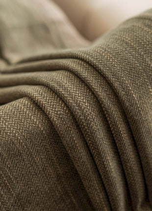 a close up of a couch with a blanket on top of it