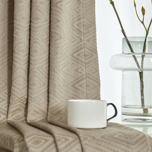 a coffee cup sitting on a table next to a vase of flowers