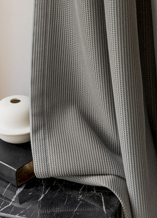 a black table with a book and a white vase on top of it