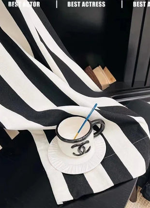 a black and white striped blanket with a blue straw