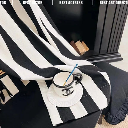 a black and white striped blanket with a blue straw