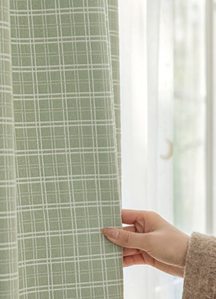 a person holding a curtain in front of a window