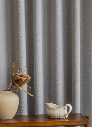 a white vase sitting on top of a wooden table
