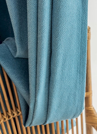 a bamboo chair with a blue blanket on top of it