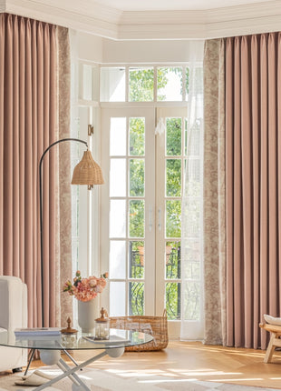 a living room filled with furniture and a window covered in pink curtains