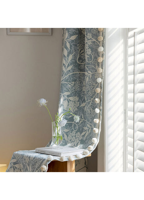 a vase with a flower on a table next to a window