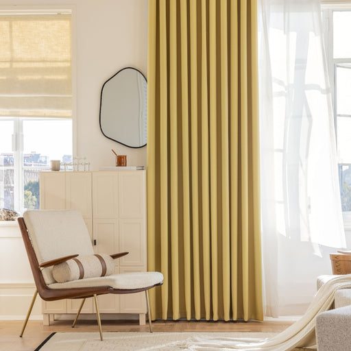 a living room with yellow curtains and a chair
