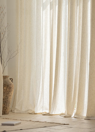 a living room with a white couch and white curtains