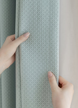 a person holding a curtain with their hand