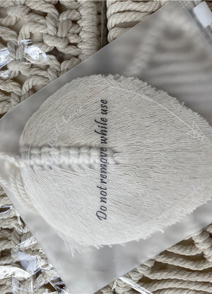 Attache Rideau Corde. Un sac en macramé blanc avec un gland blanc, parfait pour ajouter une touche déco à vos rideaux.